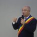 A Romanian Football figure, Emil Boc, in a suit and tie speaking into a microphone amidst controversy.