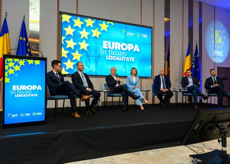 A group of people embracing European values, sitting on stage in front of a screen in Cluj.