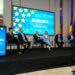 A group of people embracing European values, sitting on stage in front of a screen in Cluj.