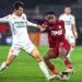 Two soccer players from CFR Cluj fighting for the ball on a soccer field during the regular season.